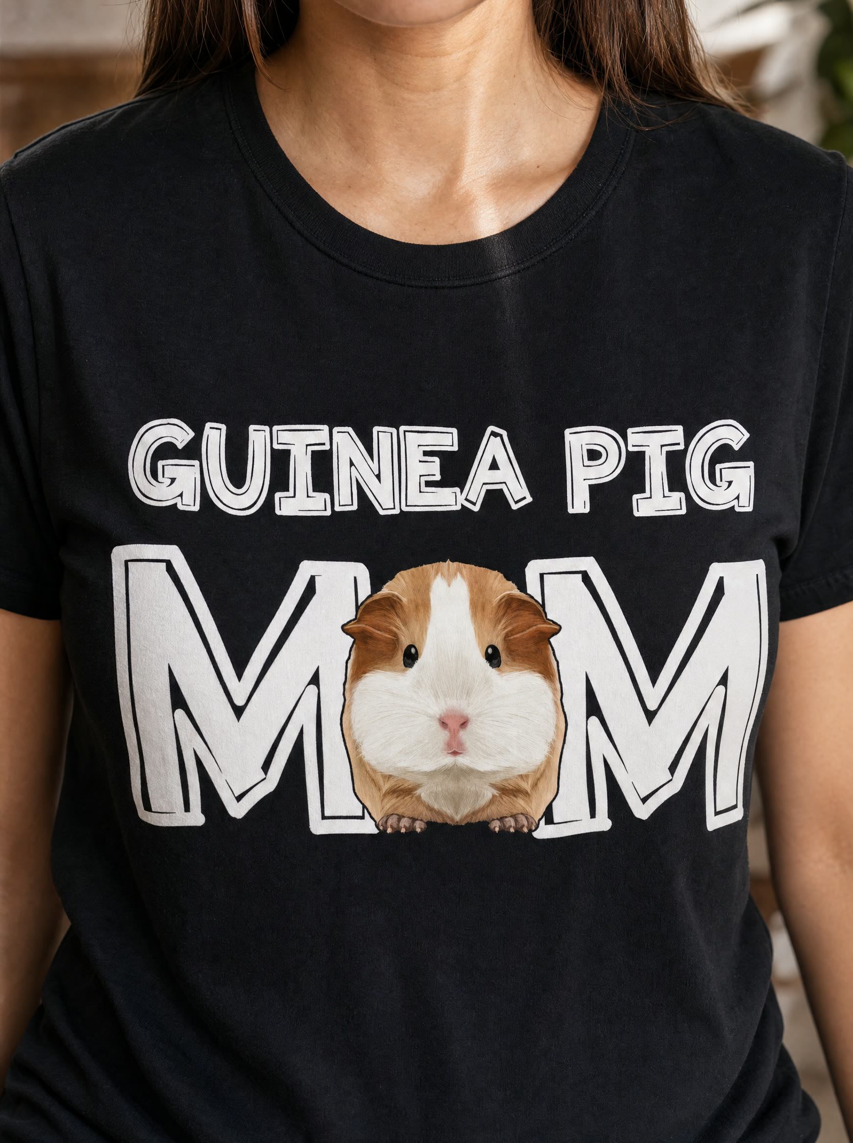 Closeup of the Guinea Pig Mom print on a black cotton tee with the guinea pig replacing the first O