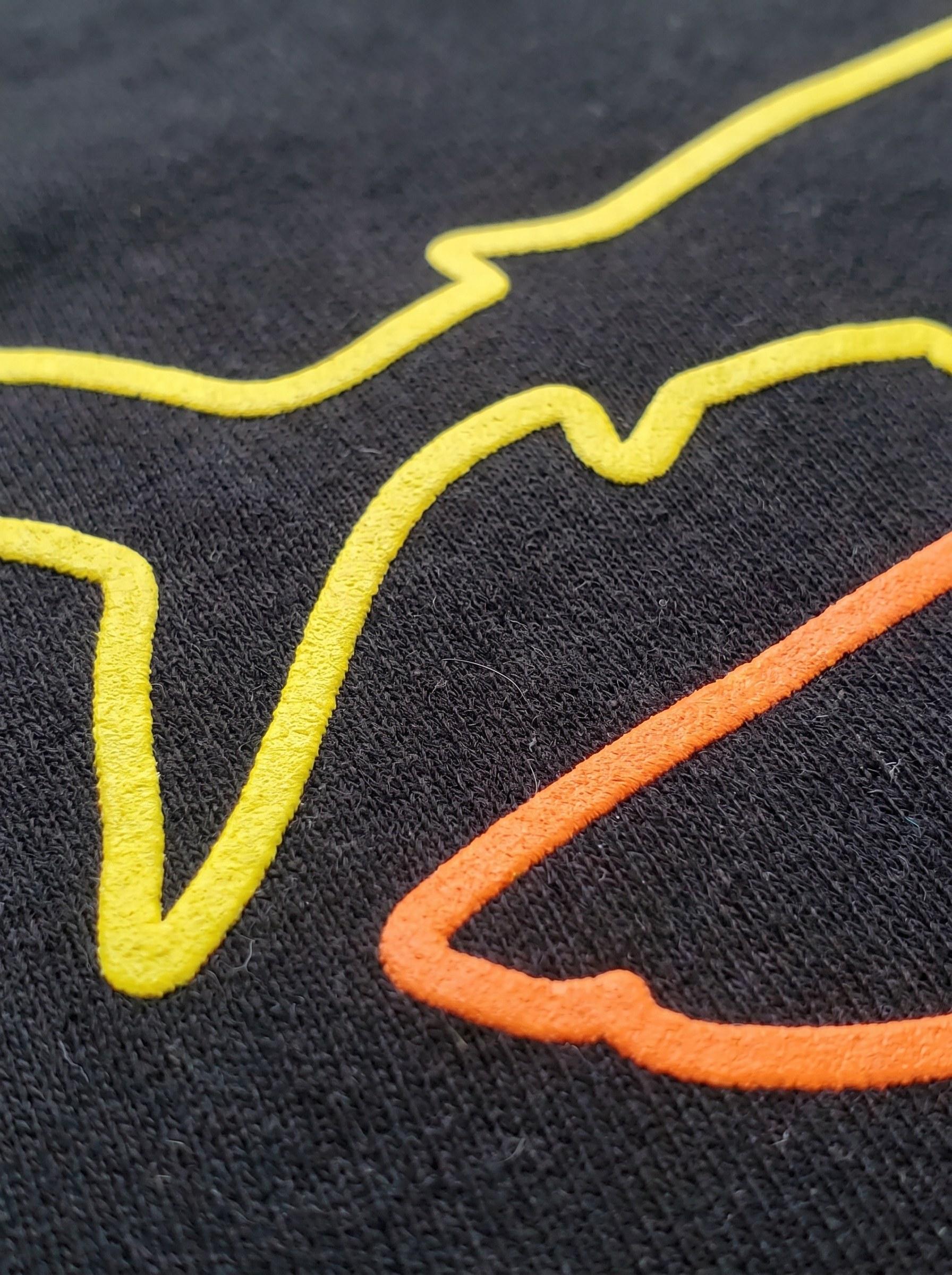 Macro of the flat matte shark print on black cotton showing the ink sitting on the fabric weave